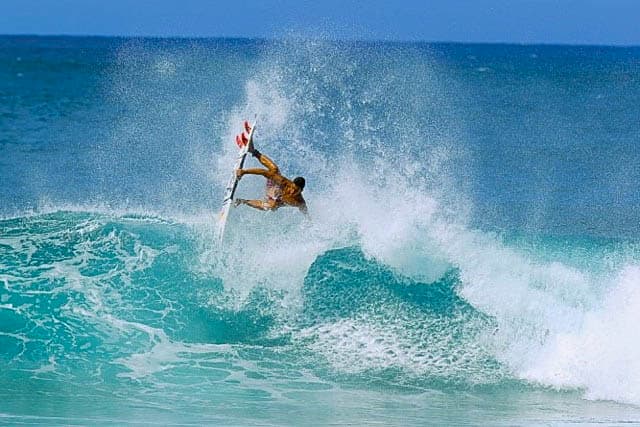 a man riding a wave on a beautiful blue ocean